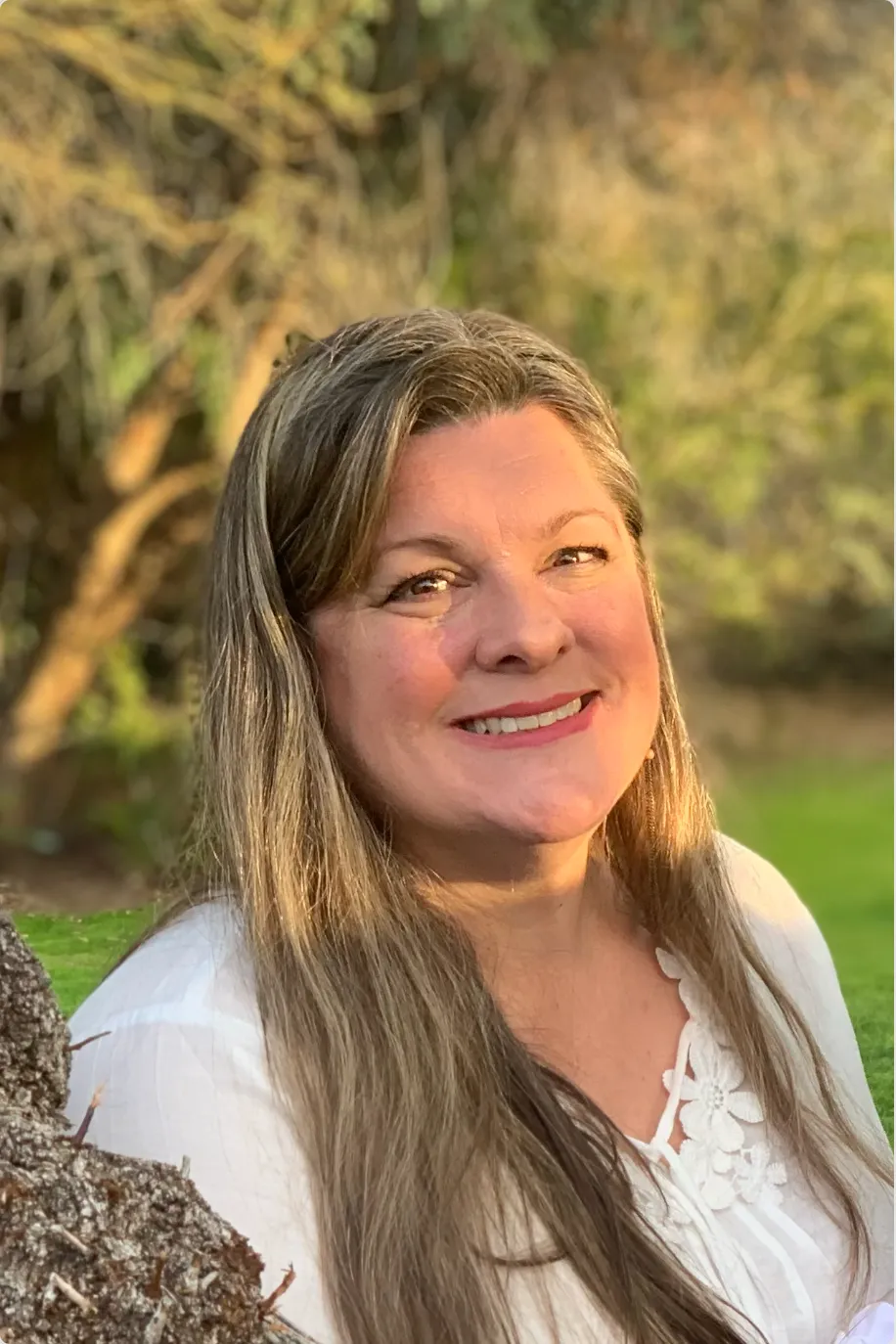 Valarie smiling in warm Phoenix golden-hour light with desert greenery behind